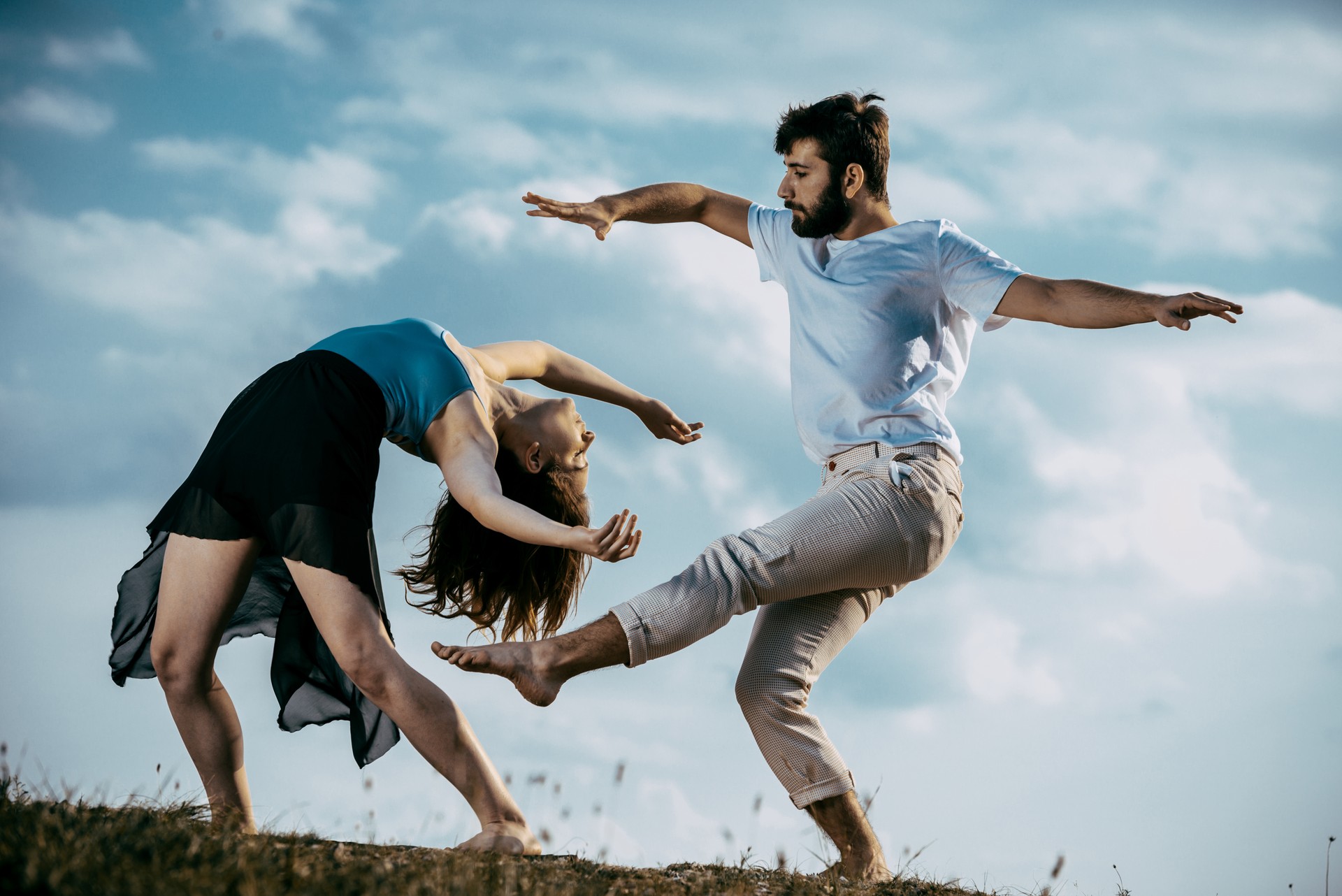 Acrobat pose of a two talented, young dancers at the mountain