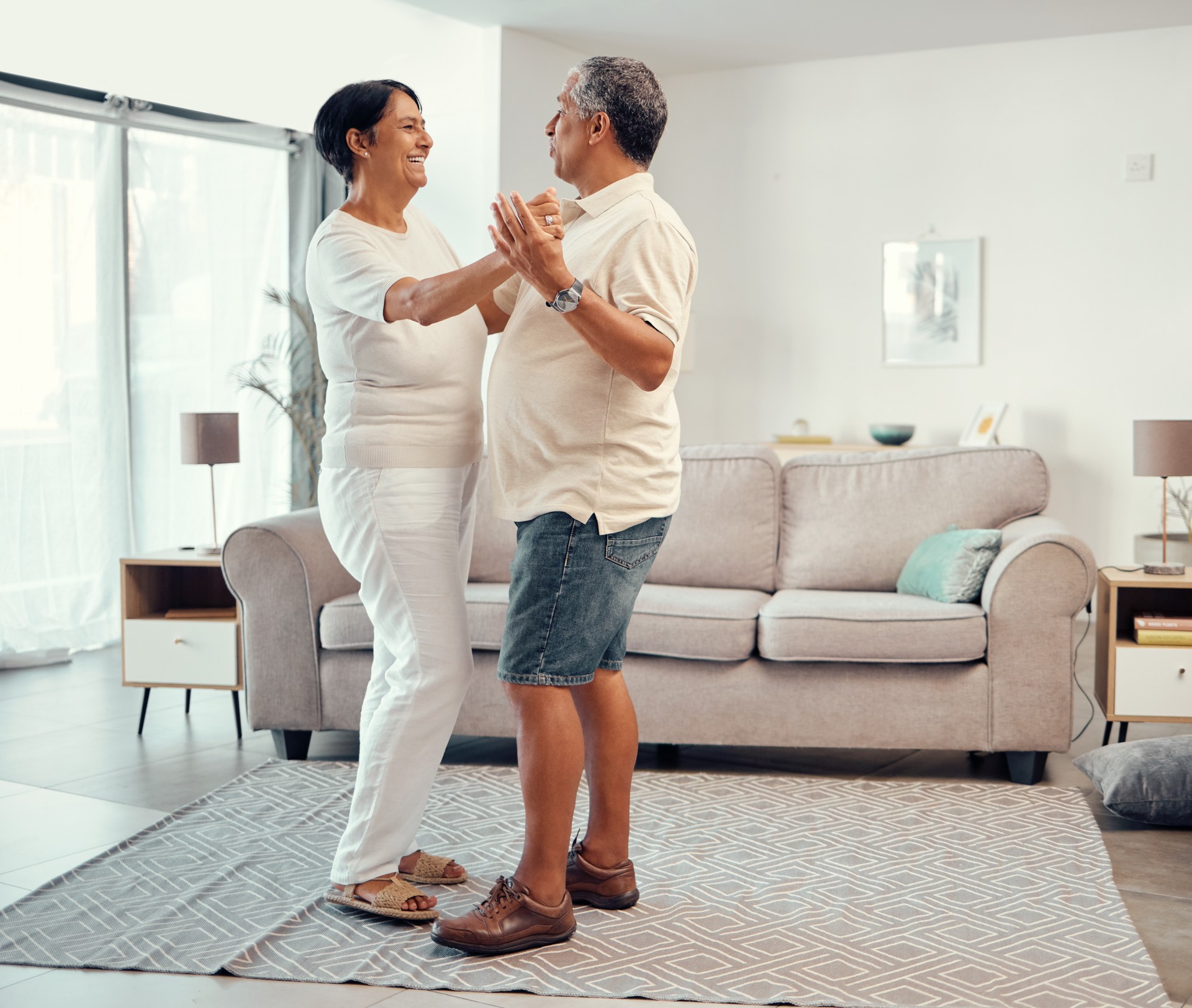 Senior couple dancing in living room home for love, retirement or real estate. Dance together, celebration of marriage and elderly people smile. hug and share life with affection, freedom and care