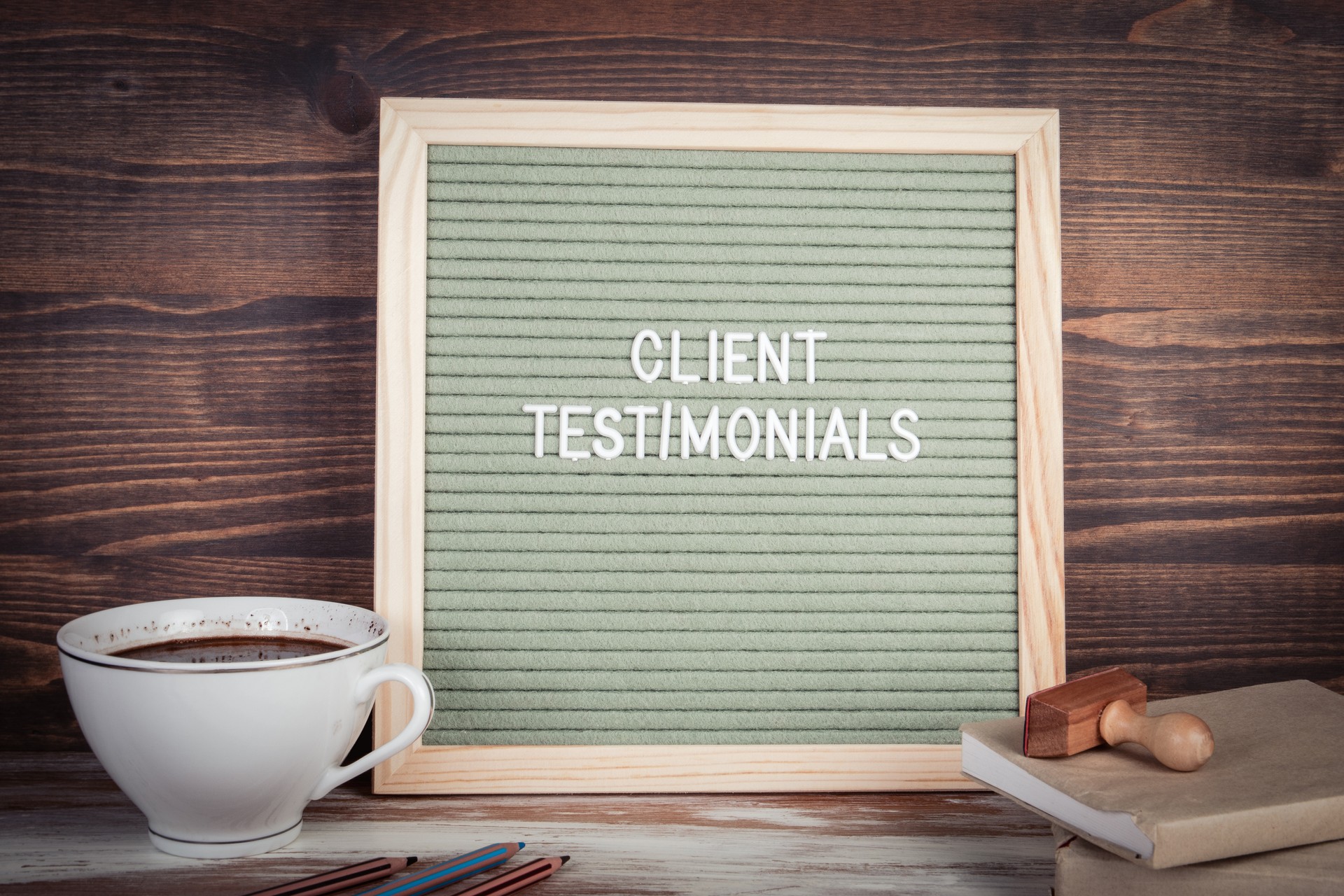 Client Testimonials.  English text on a letter Board. Stationery on a wooden table