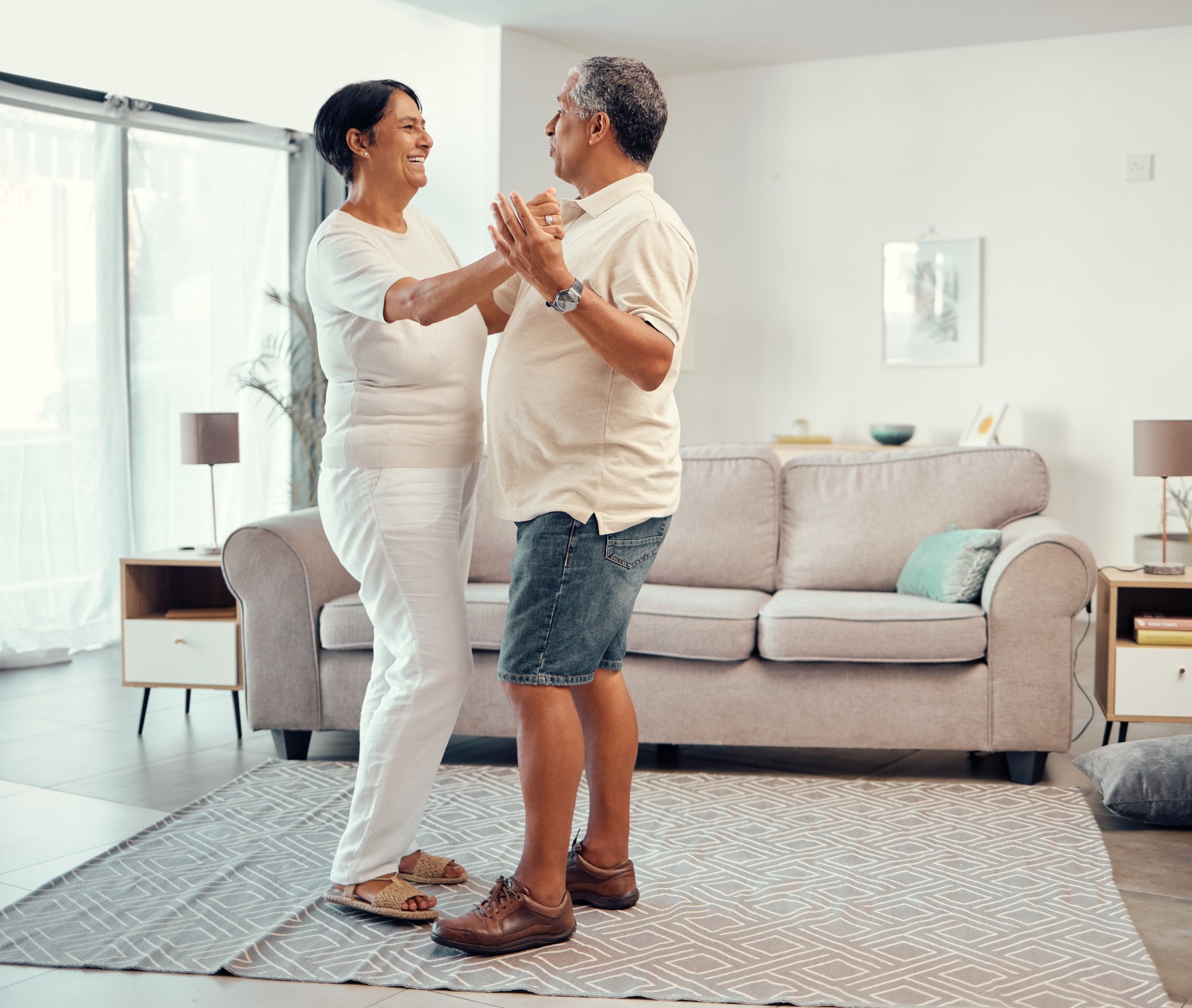 Senior couple dancing in living room home for love, retirement or real estate. Dance together, celebration of marriage and elderly people smile. hug and share life with affection, freedom and care